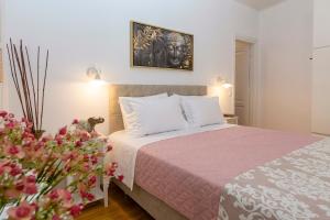 sypialnia z łóżkiem z różowym kocem i kwiatami w obiekcie Nobilis Corfu apartment w Korfu