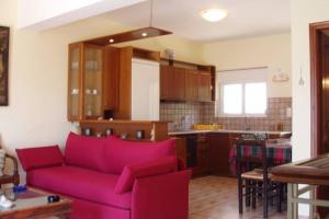 a living room with a red couch and a kitchen at Cephalonia Sami, luxury apartment. in Sami