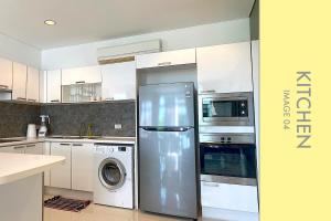 a kitchen with a refrigerator and a washer and dryer at Stylish Condo w. Pool View 2F in Kamala Beach
