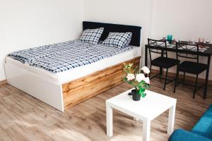 1 dormitorio con 1 cama, mesa y sillas en SouvenirAppart Wilenska, en Bydgoszcz