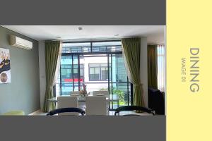 a room with a table and chairs and a large window at Stylish Condo w. Pool View 2F in Kamala Beach