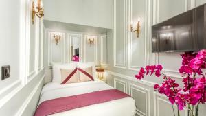 a room with a bed with pink flowers in it at Luxury 3 bedroom Loft in Heritage Building - LE MARAIS in Paris