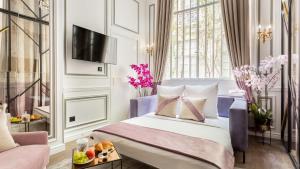 a hotel room with a bed and a tv at Luxury 3 bedroom Loft in Heritage Building - LE MARAIS in Paris
