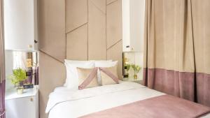 a bedroom with a large white bed with a headboard at Luxury 3 bedroom Loft in Heritage Building - LE MARAIS in Paris