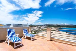 two chairs on a balcony with a view of the ocean at Cala Agulla 1 in Cala Ratjada