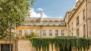 a large building with a fence in front of it at Luxury 3 bedroom Loft in Heritage Building - LE MARAIS in Paris