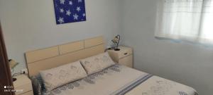 a bedroom with a bed with a blue and white comforter at 1ere soleil levant in Puerto de Sagunto