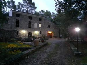 un gran edificio de piedra con patio por la noche en Molí dels Aubins, en Cornudella