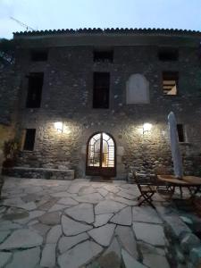 een stenen gebouw met een tafel en een bank ervoor bij Molí dels Aubins in Cornudella