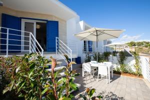 una casa con patio con tavolo e ombrellone di Residenziale Blu 1 a Marina di Pescoluse