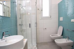 La salle de bains est pourvue d'une douche, d'un lavabo et de toilettes. dans l'établissement Residenziale Blu 1, à Marina di Pescoluse