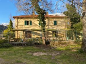 una casa vieja con una valla delante de ella en Villa Oracola, en Rieti