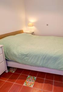 - une chambre avec un lit et une lampe au sol carrelé dans l'établissement Cabanon de Malmousque, à Marseille