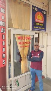a man standing in front of a welcome reception window at CITY CROWN GUEST HOUSE in Sundarnagar