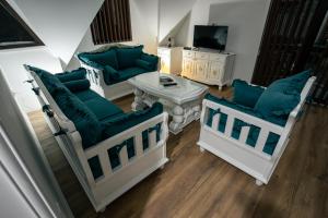 a living room with three chairs and a table at Vila ZLATARSKA PAHULJA --- apartman " BELE NOĆI " in Nova Varoš