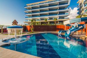 a pool with a water slide in front of a building at Eco Marine Residence in Kargicak