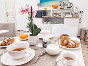 - une table avec des tasses de café et des pâtisseries dans l'établissement Ai Quartieri, à Palerme