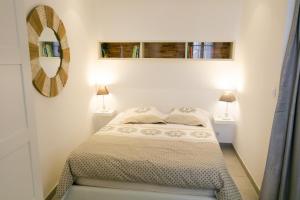 a small bedroom with a bed and two lamps at studio Vaucluse Clovis in L'Isle-sur-la-Sorgue