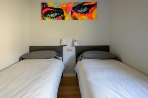- 2 lits dans une chambre ornée d'une peinture murale dans l'établissement Apartamento frente telecabina Vallnord - Bike park 641, à La Massana