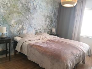 um quarto com uma cama com papel de parede floral em City Apartment Savonkatu em Kuopio