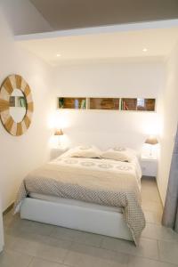 リル・シュル・ラ・ソルギュにあるstudio Vaucluse Clovisの白いベッドルーム(ベッド1台、鏡付)