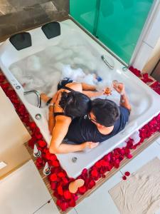 einen Kuchen mit zwei Personen in einer Badewanne mit Rosen in der Unterkunft Pousada Araras in Alto Paraíso de Goiás