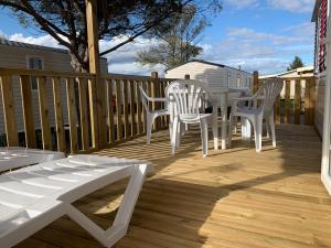 una terrazza in legno con tavolo e sedie. di Mobil Home Canet plage a Canet-en-Roussillon