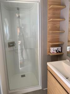 a shower with a glass door in a bathroom at Mobil Home Canet plage in Canet-en-Roussillon