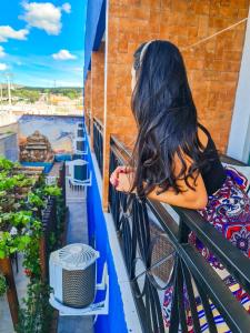 a woman sitting on a balcony looking out at the water at Pousada Araras in Alto Paraíso de Goiás