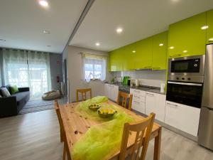 cocina con mesa de madera y armarios amarillos en Cantinho Verde T1, en Gerês