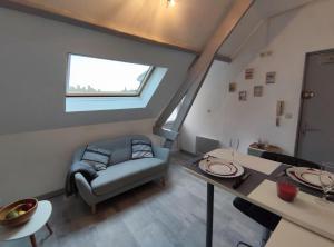 un salon avec un canapé et une table dans l'établissement Joli petit T2 terrasse proche du phare, à Calais 11 autres photos