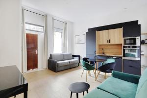 a living room with a couch and a table at Majesti apartment in Marais - Rue du Petit Musc in Paris