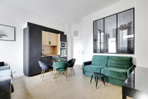 a living room with a green couch and chairs at Majesti apartment in Marais - Rue du Petit Musc in Paris