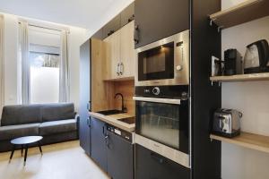 a kitchen with a stove and a microwave at Majesti apartment in Marais - Rue du Petit Musc in Paris