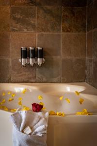 una vasca da bagno con foglie gialle sopra con due candele di A Bear and Bison Country Inn a Canmore