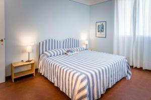 ein Schlafzimmer mit einem großen Bett und einer gestreiften Decke in der Unterkunft Maranghetto appartamenti in Caorle