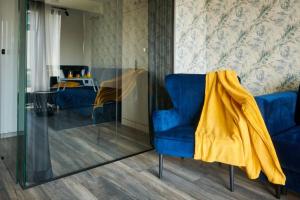 a blue chair with a yellow blanket sitting in a room at EASY RENT Apartments - Crystal, Basen & SPA, Centrum, 24h Check-in in Lublin