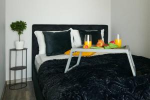 a bed with a tray of food and drinks on it at EASY RENT Apartments - Crystal, Basen & SPA, Centrum, 24h Check-in in Lublin