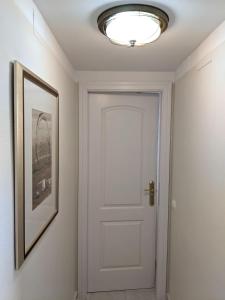 un couloir avec une porte blanche et une photo dans l'établissement Cabeho Beach Homes, à Calp