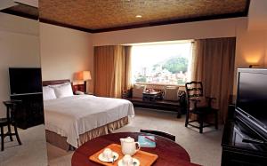 a hotel room with a bed and a large window at Beautiful Hotel Taipei in Xindian