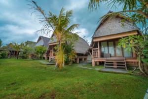 a house with a grass yard in front of it at PB Pondok Gandalangu Garden House Bali in Ubud