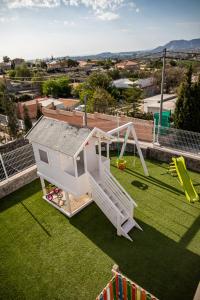 a white play structure on a lawn with a slide at MountainBeach in San Vicente del Raspeig