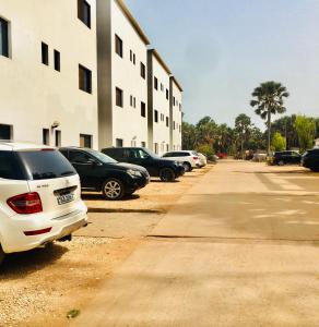 eine Reihe geparkter Autos neben einem Gebäude in der Unterkunft Gambia Seafront Central in Banjul
