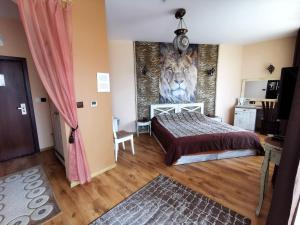 a bedroom with a bed with a lion mural on the wall at Hotel Africa in Haskovo