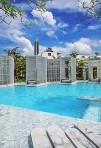 a large swimming pool with blue water and buildings at Veranda Residence pattaya By Sea in Jomtien Beach