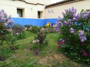 un jardín con flores púrpuras frente a un edificio en Albergue Quinta del Jalón, en Granja de San Pedro