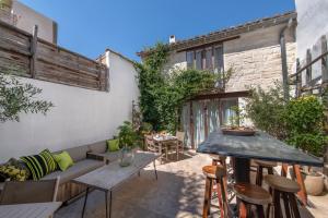 een patio met een bank en een tafel en stoelen bij Maison De Mon Père in Aigues-Mortes