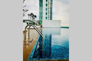 una piscina con un tobogán en un edificio en EVO DUPLEX OKED homestay, en Kampong Sungai Ramal Dalam