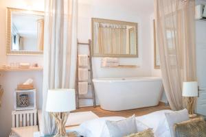 a bathroom with a bath tub and a sink and a mirror at Maison De Mon Père in Aigues-Mortes