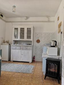 a kitchen with a stove and a microwave at Mánfa-gyöngy Vendégház in Mánfa